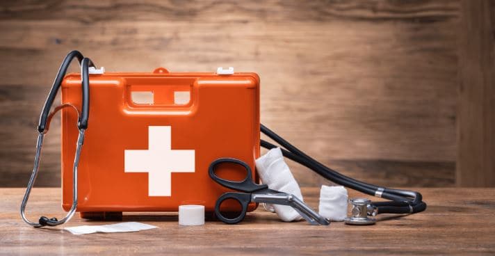A first aid kit with a few tools outside the box 